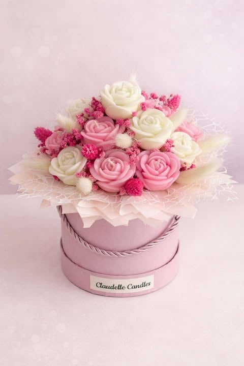 Pink decorative flower box arrangement with white and pink roses, pink carnations, and a Claudelle Candles branded container