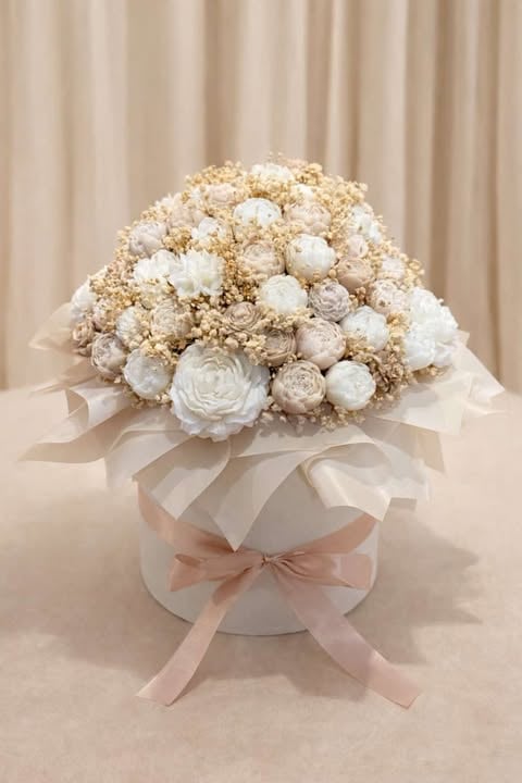 Luxurious bridal bouquet with white and cream roses and babys breath in white box with pink and white ribbons