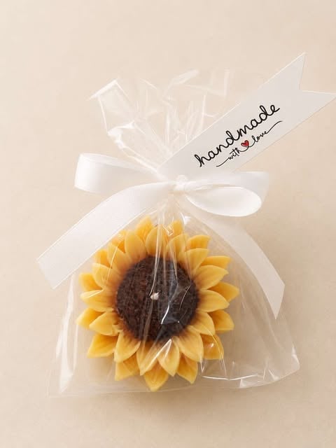 Handmade decorative sunflower cake wrapped in cellophane with white ribbon and handmade label tag